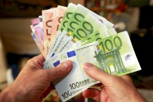 Person håller i Euro-sedlar