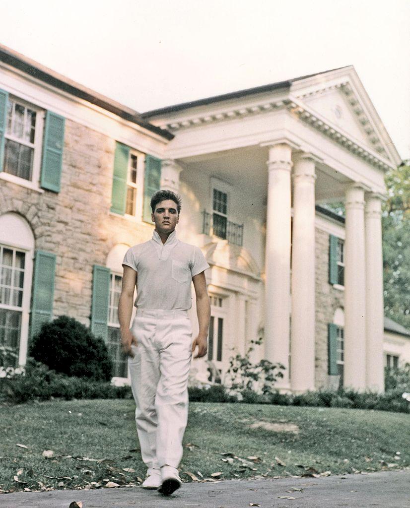 Elvis Presley som ung framför stort vitt hus. 