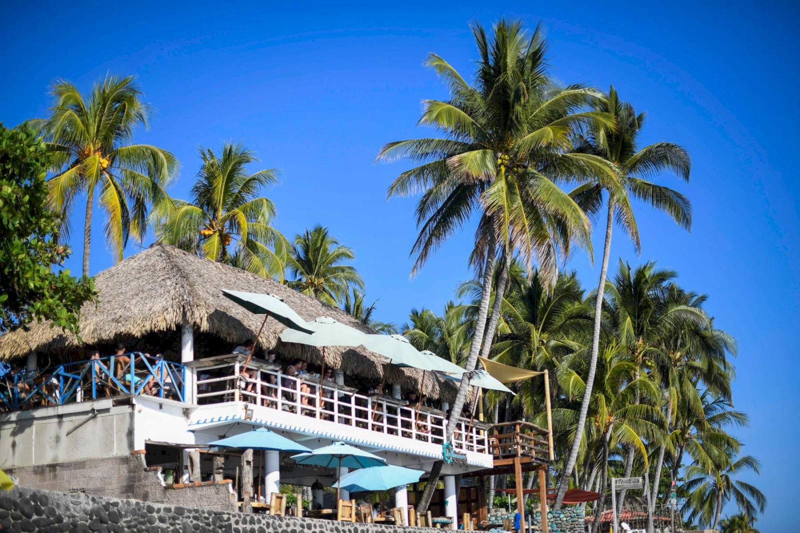 Strandrestaurang med palmer. 